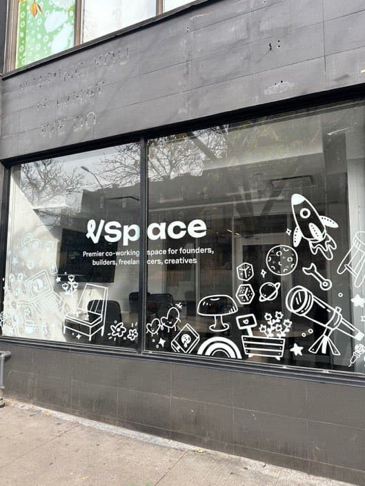 The VSpace storefront window in Toronto, with the logo and the line premier co-working space for founders, builders, freelancers and creatives